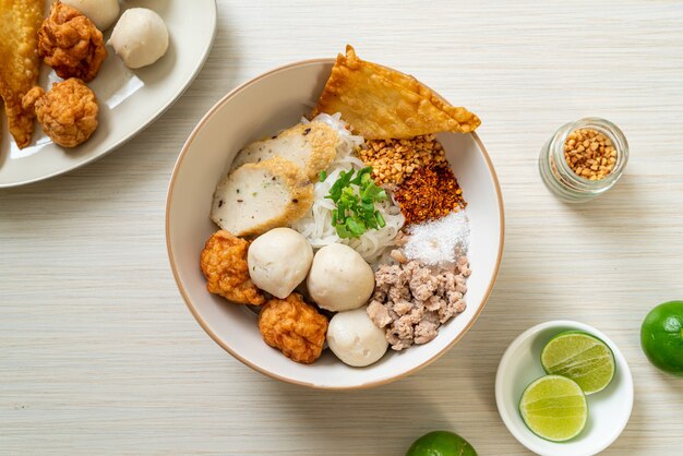 Fideos de arroz planos pequeños picantes con bolas de pescado y bolas de camarones sin sopa - estilo de comida asiática