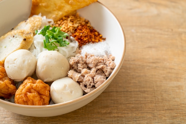 Fideos de arroz planos pequeños picantes con bolas de pescado y bolas de camarones sin sopa - estilo de comida asiática