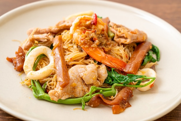 Fideos de arroz salteados y mimosa de agua con carne mixta - estilo de comida asiática