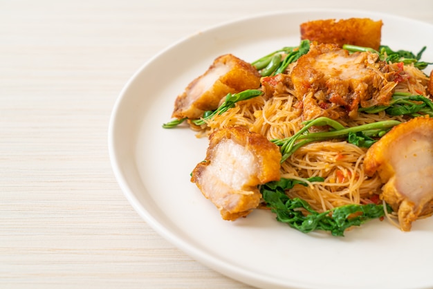 Fideos de arroz salteados y mimosa de agua con crujiente panceta de cerdo