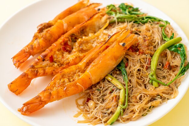 Fideos de arroz salteados y mimosa de agua con gambas de río