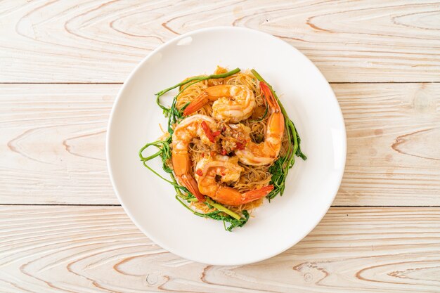 Foto fideos de arroz salteados y mimosa de agua con gambas