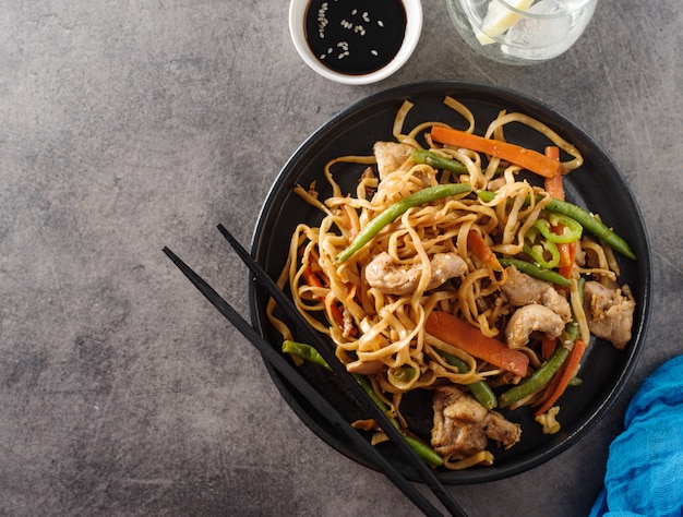 Fideos asiáticos con carne de cerdo en salsa teriyaki, con judías verdes, zanahorias y champiñones shiitake.