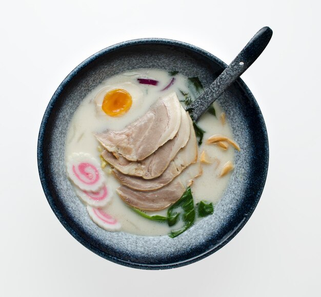 Fideos asiáticos Miso Ramen con cerdo al huevo y repollo pak choi en un tazón sobre fondo oscuro