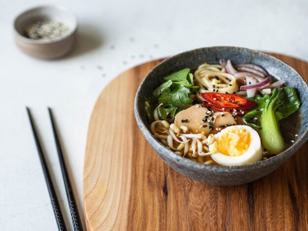 Fideos asiáticos de ramen con pollo, repollo pak choi y huevo