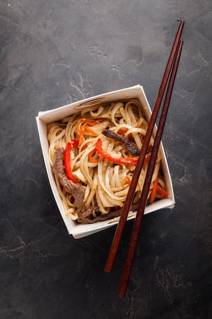 Fideos en una caja con verduras y ternera.