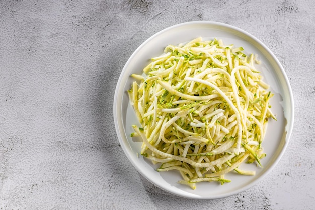 Fideos de calabacín crudos en un plato sobre la mesa