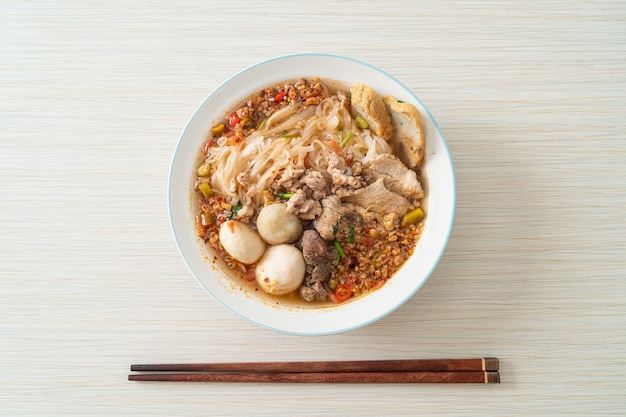 fideos con carne de cerdo y albóndigas en sopa picante o fideos Tom yum al estilo asiático