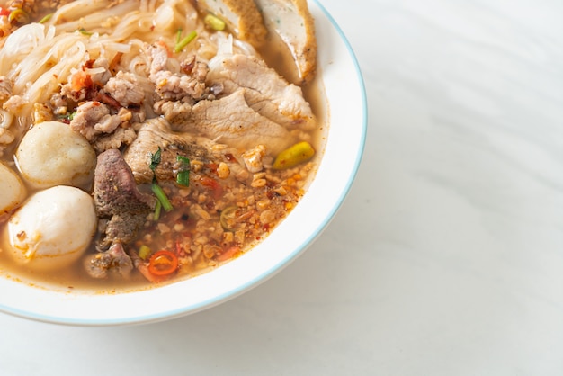 fideos con carne de cerdo y albóndigas en sopa picante o fideos Tom yum al estilo asiático