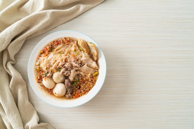 fideos con carne de cerdo y albóndigas en sopa picante o fideos Tom yum al estilo asiático