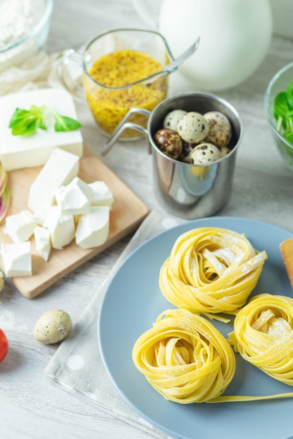 Fideos caseros italianos crudos de pasta típica linguini en placa