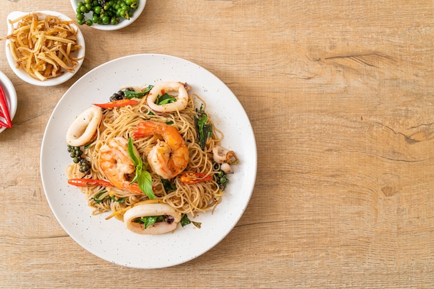 fideos chinos salteados con albahaca, guindilla, gambas y calamares, estilo de comida asiática