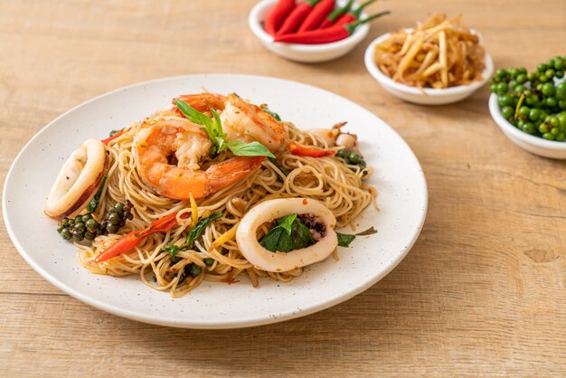 fideos chinos salteados con albahaca, guindilla, gambas y calamares, estilo de comida asiática