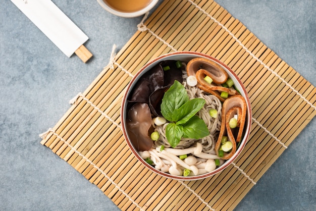 Foto fideos chinos con verduras seta y palillos