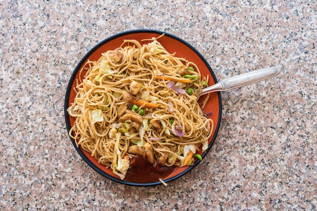 Fideos Chow Mein asiáticos con carne de pollo y verduras. Plato popular de la cocina oriental. Foto de stock.