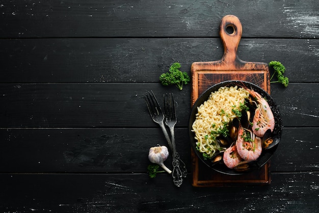 Fideos de cocina tradicional asiática con gambas y mejillones Platos de marisco Vista superior Espacio libre para el texto