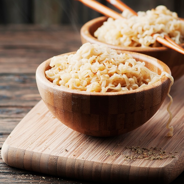 Fideos de comida rápida asiática en tazones con palillos