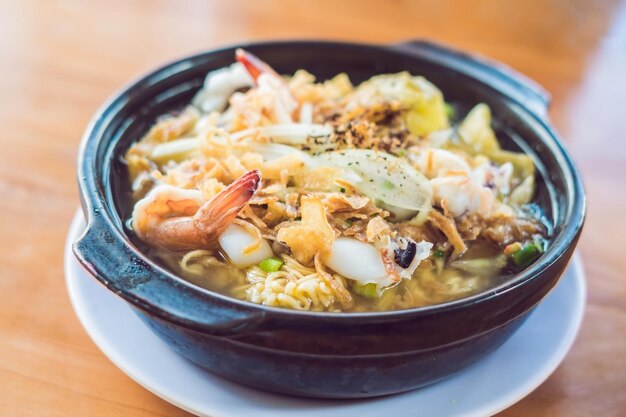 Fideos coreanos con camarones, pulpos y kimchi.