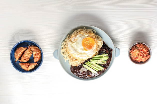 Fideos coreanos Jajang Myeon o JJajangmyeon con salsa de frijoles negros, servidos con pepino y semillas de sésamo