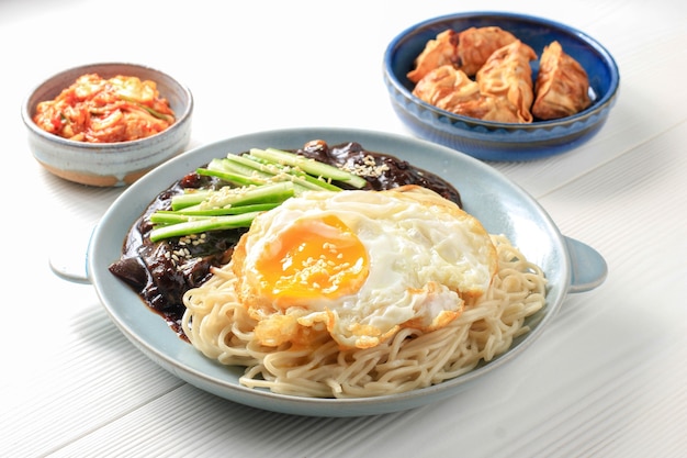 Fideos coreanos Jajang Myeon o JJajangmyeon con salsa de frijoles negros, servidos con pepino y semillas de sésamo