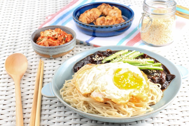 Fideos coreanos Jajang Myeon o JJajangmyeon con salsa de frijoles negros, servidos con pepino y semillas de sésamo