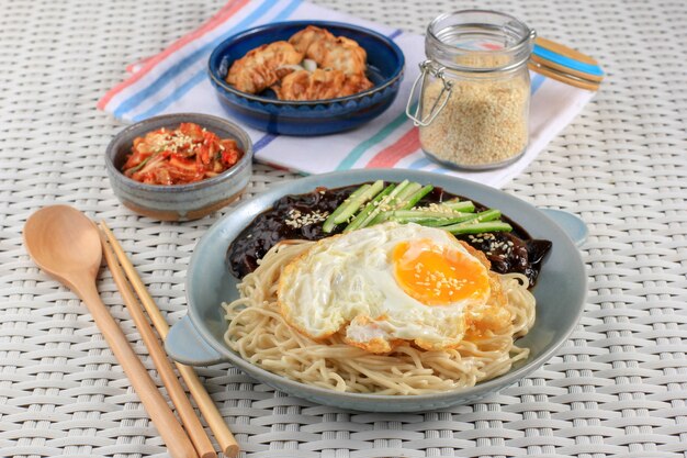 Fideos coreanos Jajang Myeon o JJajangmyeon con salsa de frijoles negros, servidos con pepino y semillas de sésamo