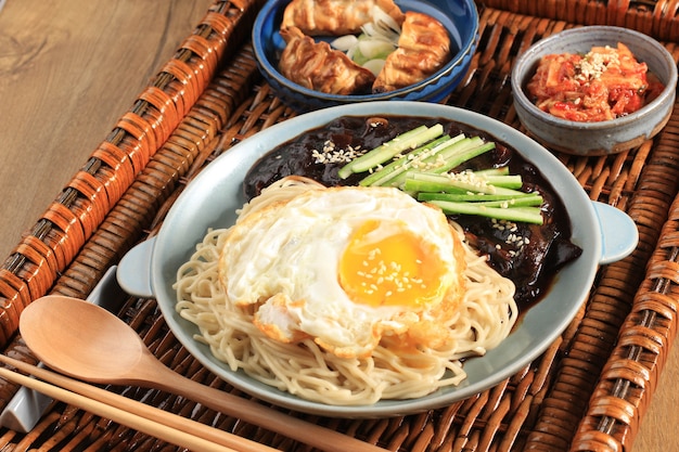 Fideos coreanos Jajang Myeon o JJajangmyeon con salsa de frijoles negros, servidos con pepino y semillas de sésamo