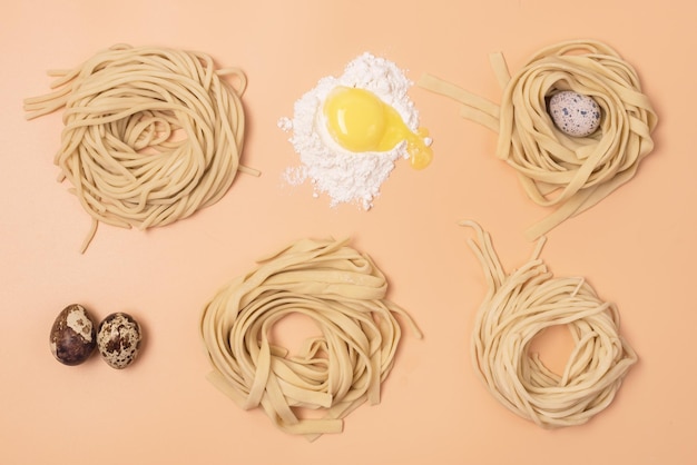 Fideos crudos hechos a mano, huevos y harina sobre fondo amarillo Vista superior horizontal Pasta italiana