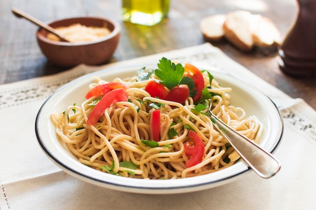 Fideos deliciosos cocinados en un plato blanco sobre el mantel