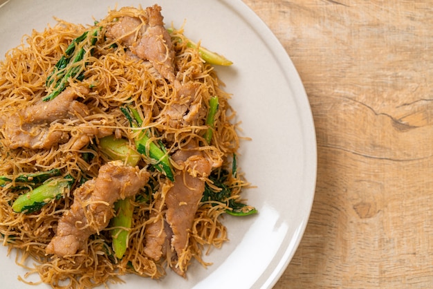 Fideos fideos de arroz salteados con salsa de soja negra y cerdo - estilo de comida asiática