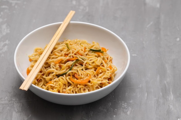 Fideos frescos y sabrosos con verduras en un tazón blanco