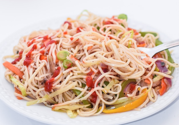 Fideos fritos con vegetales coloridos en un plato