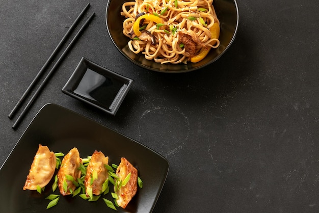 Fideos gyoza y udon sobre un fondo oscuro vista superior comida asiática albóndigas fritas japonesas udo chino