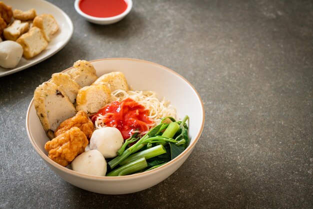 Foto fideos de huevo con bolas de pescado y bolas de camarón en salsa rosa yen ta four o yen ta fo