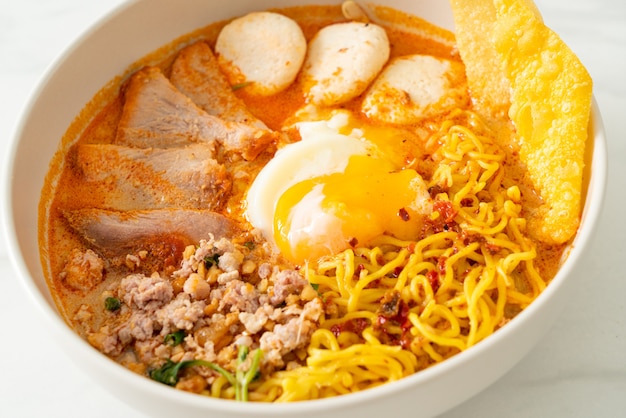 fideos de huevo con carne de cerdo y albóndigas en sopa picante o Tom Yum Noodles al estilo asiático