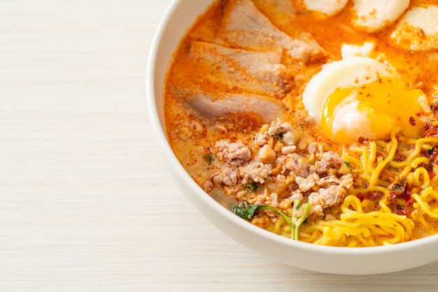 fideos de huevo con carne de cerdo y albóndigas en sopa picante o Tom Yum Noodles al estilo asiático