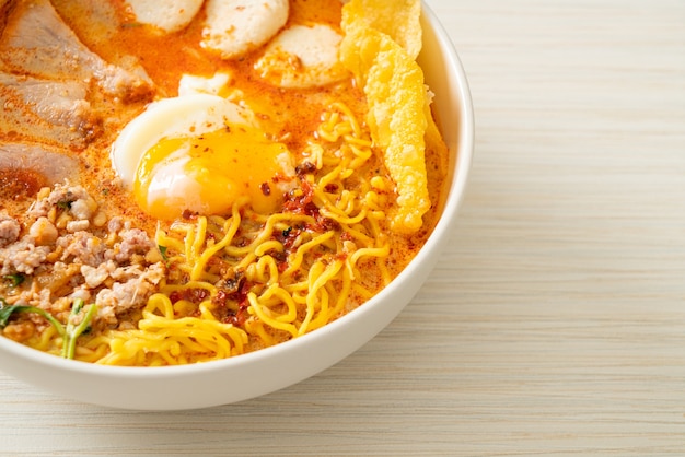 fideos de huevo con carne de cerdo y albóndigas en sopa picante o Tom Yum Noodles al estilo asiático