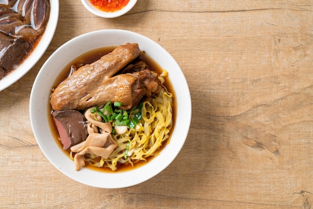 Fideos de huevo con pato guisado y estofado en sopa marrón