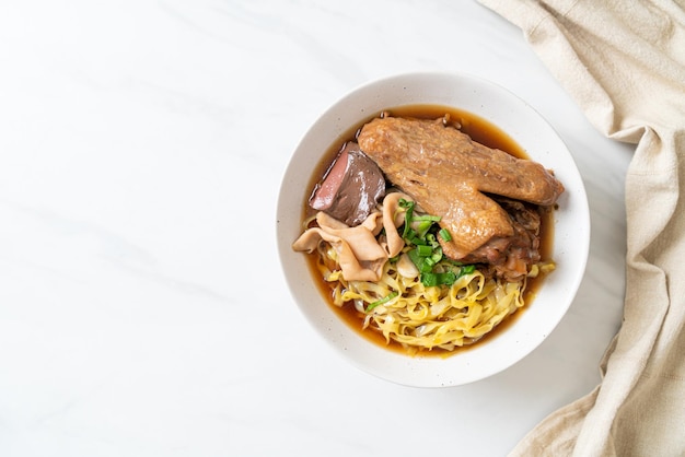 Fideos de huevo con pato guisado y estofado en sopa marrón