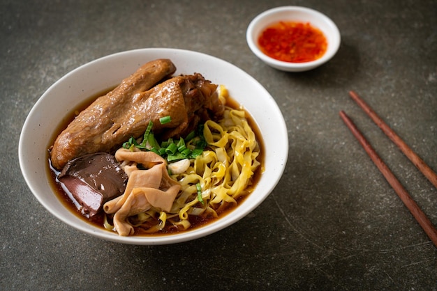 Fideos de huevo con pato guisado y estofado en sopa marrón