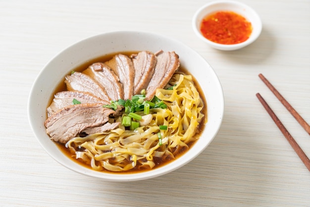 fideos de huevo con pato guisado en sopa marrón - Estilo de comida asiática