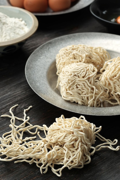 Fideos de huevo ramen crudos sobre fondo de mesa de madera negra