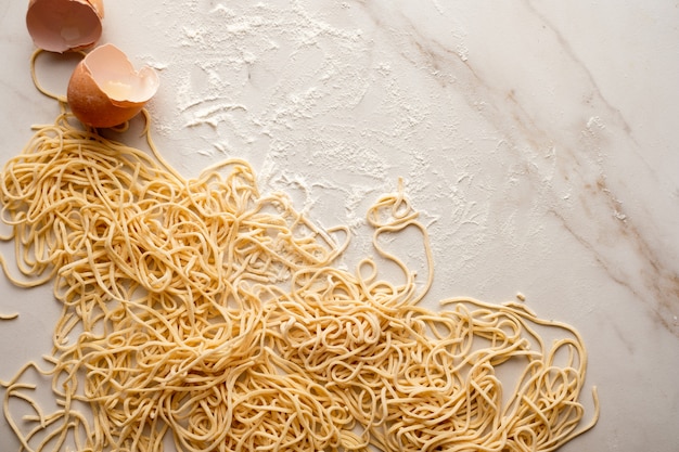 Foto fideos de huevo seco, espagueti fresco crudo