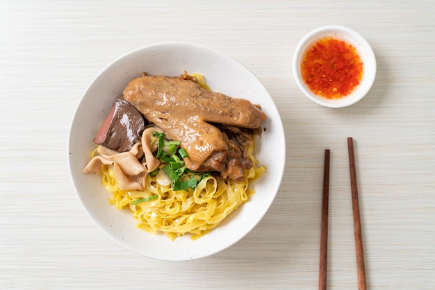 Fideos de huevo servidos secos con pato estofado