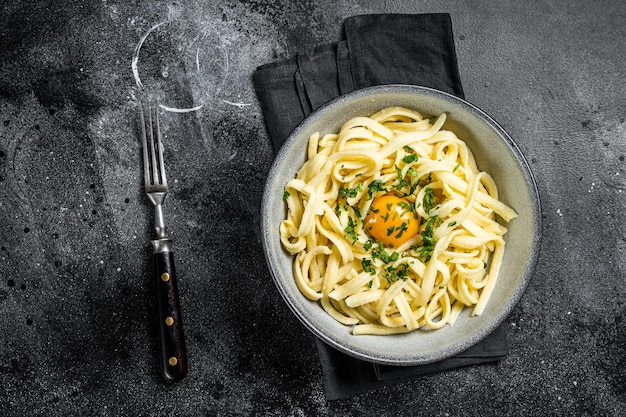 Fideos de huevo Spaetzle bávaros tradicionales con mantequilla y perejil Fondo negro Vista superior