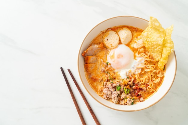 fideos instantáneos con carne de cerdo y albóndigas en sopa picante o fideos Tom Yum al estilo asiático