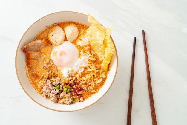 fideos instantáneos con cerdo y albóndigas en sopa picante o Tom Yum Noodles al estilo asiático