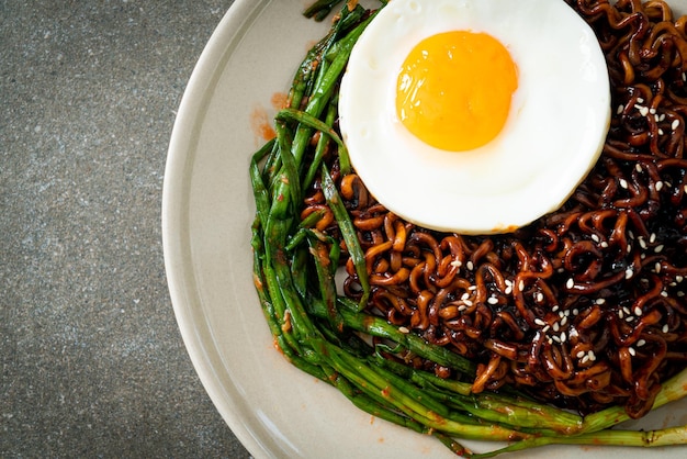 Fideos instantáneos coreanos secos con salsa negra picante con huevo frito y kimchi