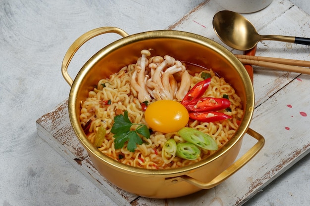 Fideos instantáneos de estilo coreano ramyoen o ramyun con sabor picante cubierto con chile de yema de huevo y etc.