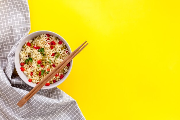 Fideos instantáneos con pimiento, guisantes, palillos